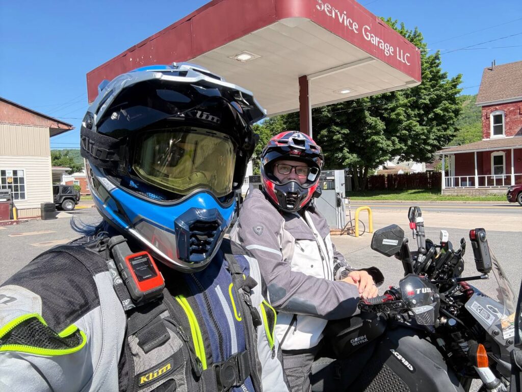 Emily wearing a KLIM Krios Pro helmet with KLIM Edge off-road goggles at a fuel stop