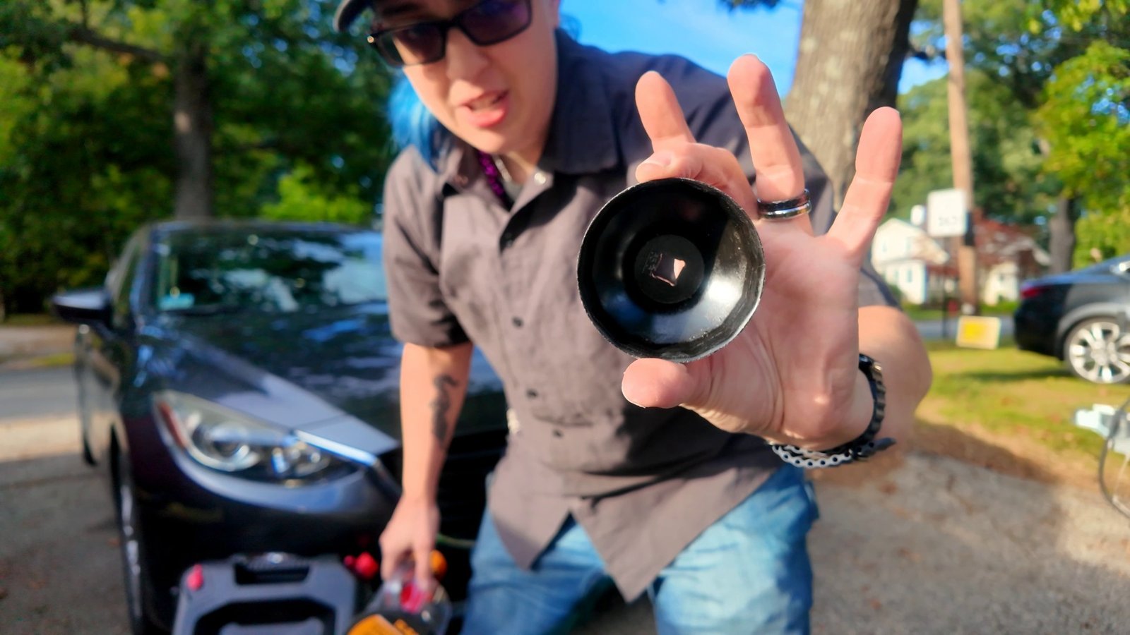 Emily holding a filter cap wrench up to the camera