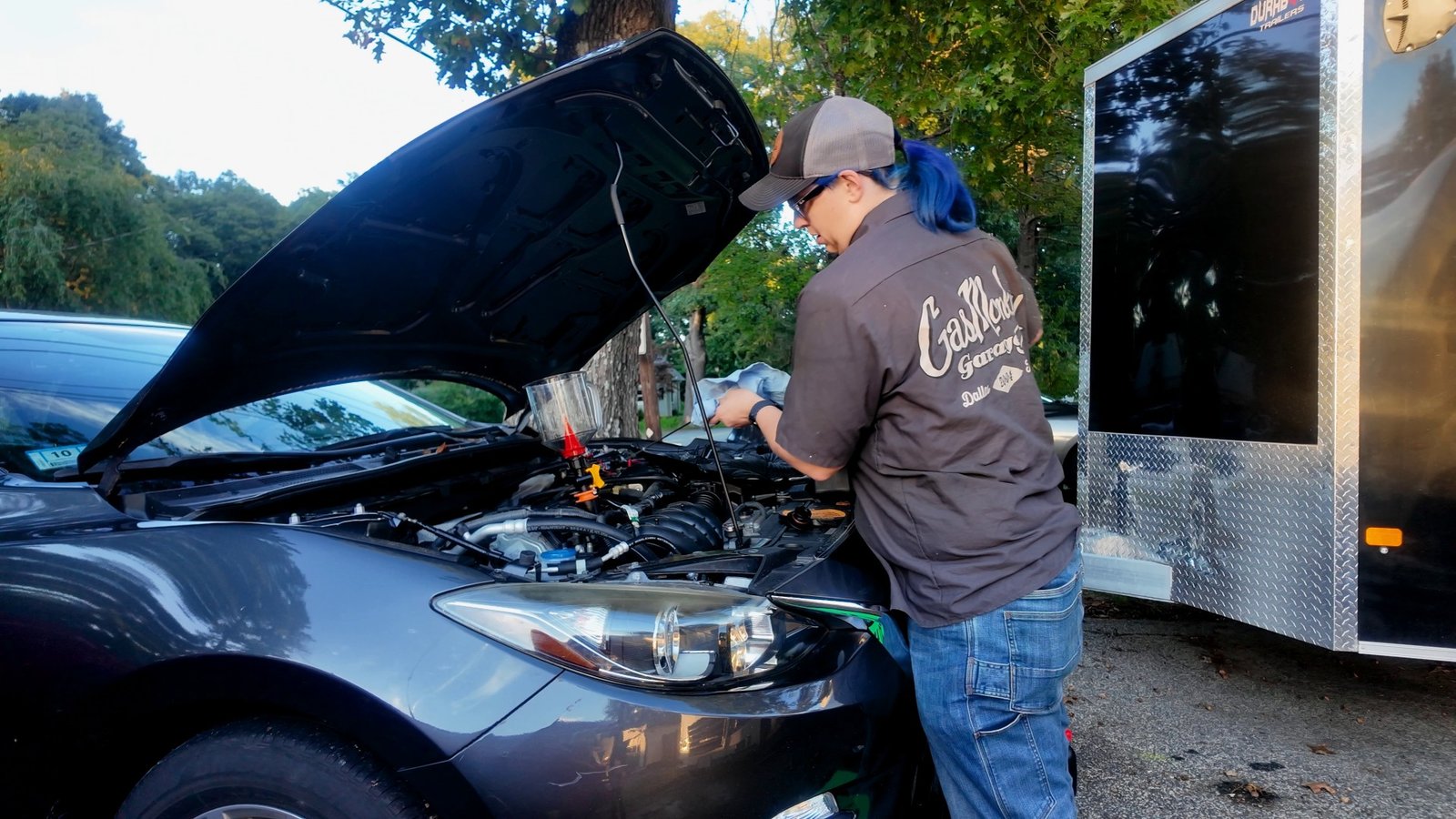Emily filling the Mazda 3 with oil under the open hood