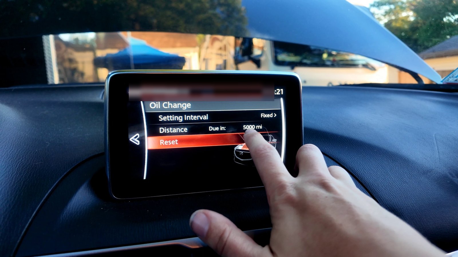 Mazda 3 infotainment screen on the Oil Change maintenance page with Reset highlighted