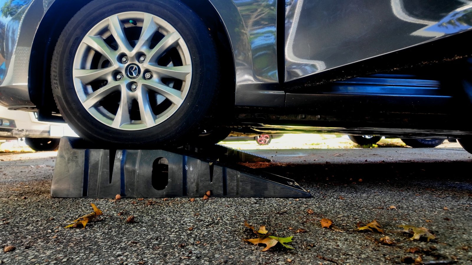 Front wheel of a Mazda 3 sitting centered on a car ramp
